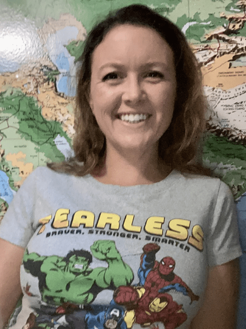 Woman in superhero shirt "Fearless" in front of world map