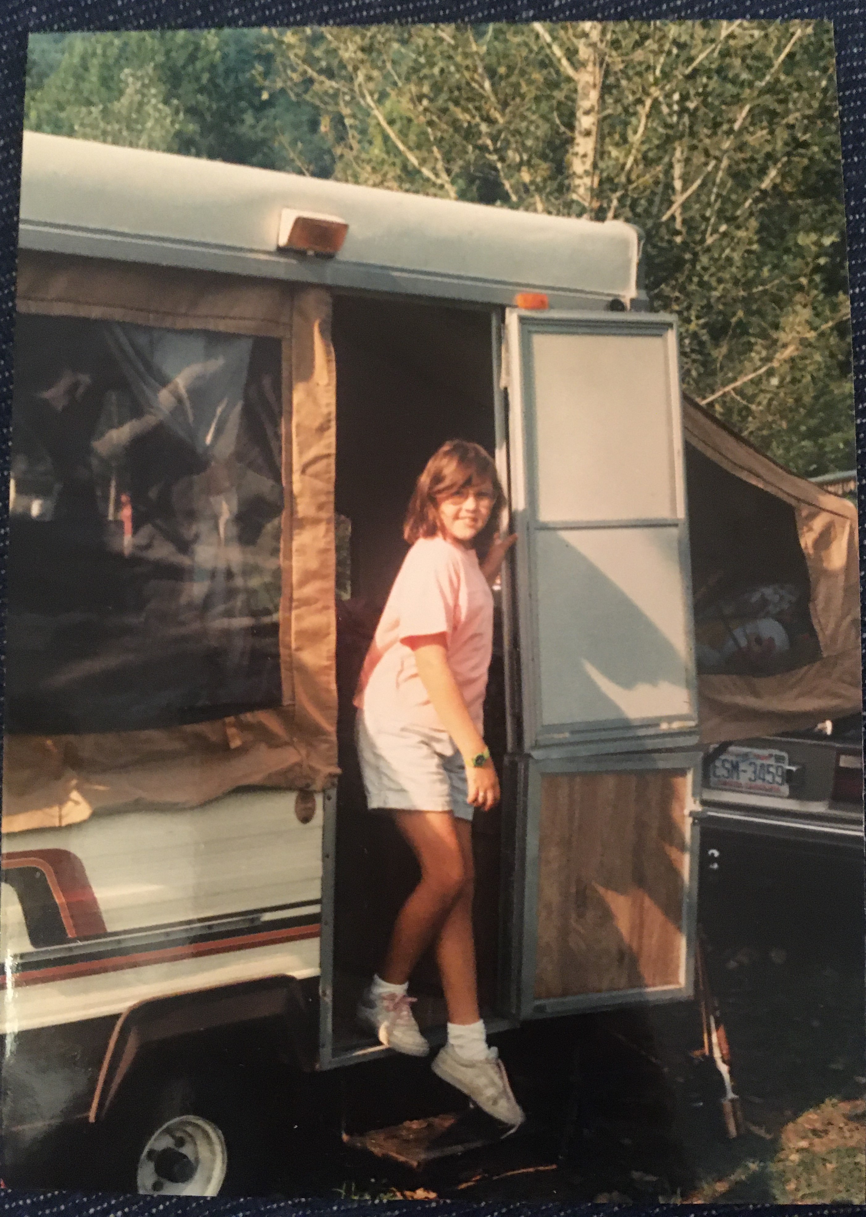 Girl stepping out of a pop-up camper